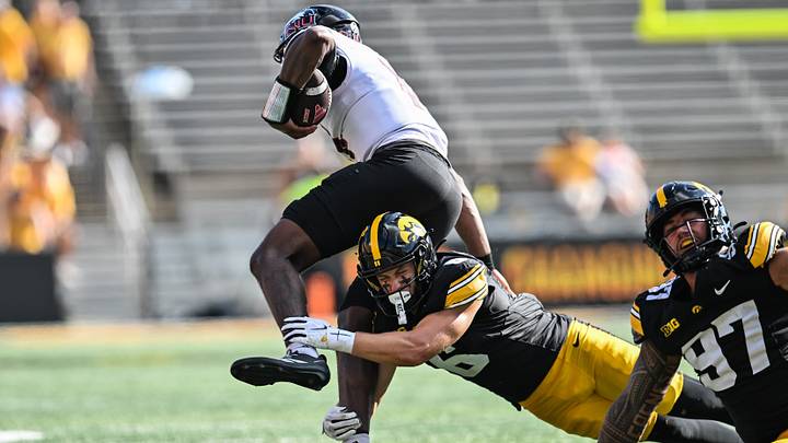 Sep 5, 2026; Iowa City, Iowa, USA;  Iowa Hawkeyes defensive back Zach Lutmer (6) tackles Northern Illinois Huskies quarterback Jalen Macon (14) as defensive end Iose Epenesa (97) looks on during the second quarter at Kinnick Stadium.  Mandatory Credit: Jeffrey Becker-Imagn Images