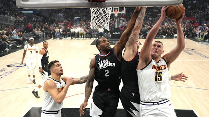 Dec 6, 2023; Los Angeles, California, USA; Denver Nuggets center Nikola Jokic (15) shoots the ball against LA Clippers forward Kawhi Leonard (2) and center Ivica Zubac (40) in the first half at Crypto.com Arena. Mandatory Credit: Kirby Lee-Imagn Images