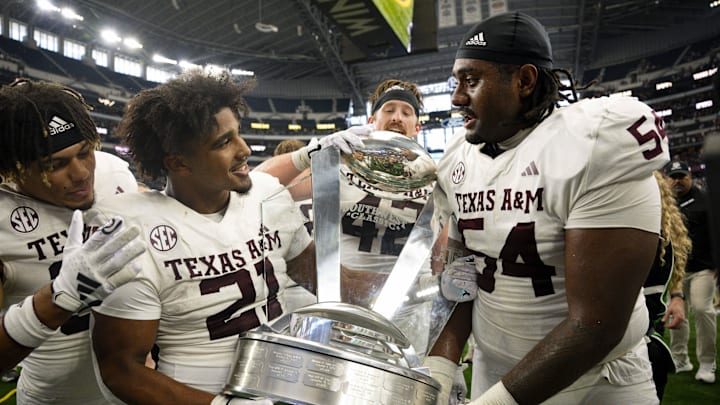 Sep 30, 2023; Arlington, Texas, USA; Texas A&M Aggies linebacker Taurean York (21) and linebacker Danny Lockhart Jr. (54) celebrate with the Southwest Classic trophy after the Aggies victory over the Arkansas Razorbacks at AT&T Stadium.
