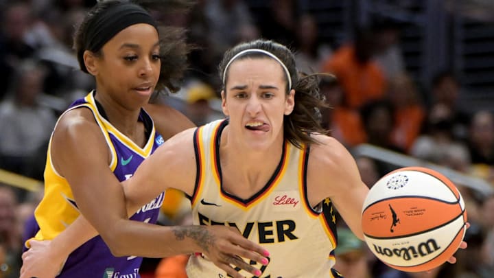 May 24, 2024; Los Angeles, California, USA;   Indiana Fever guard Caitlin Clark (22) drives past Los Angeles Sparks guard Lexie Brown (4) in the first half at Crypto.com Arena. Mandatory Credit: Jayne Kamin-Oncea-Imagn Images