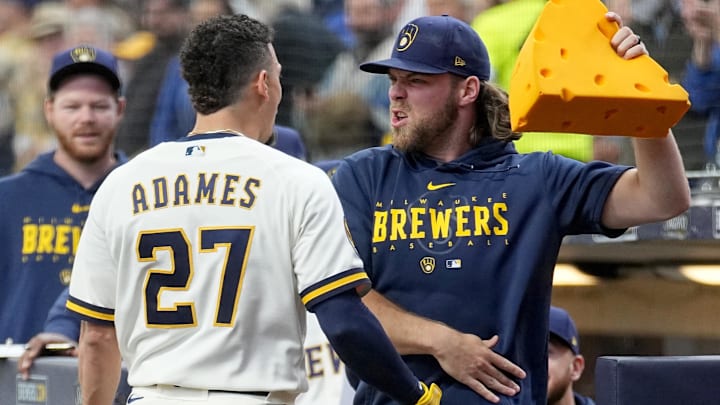 May 24, 2023; Milwaukee, Wisconsin, USA; Milwaukee Brewers starting pitcher Corbin Burnes gets ready to crown shortstop Willy Adames (27) with a Cheesehead after he hit a two-run home run during the first inning of their game against the Houston Astros at American Family Field. Mandatory Credit: Mark Hoffman-Imagn Images