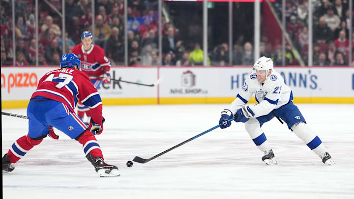 Dec 9, 2025; Montreal, Quebec, CAN;Tampa Bay Lightning forward Brayden Point (21) plays the puck and Montreal Canadiens defenseman Jayden Struble (47) defends during the first period at the Bell Centre. Mandatory Credit: Eric Bolte-Imagn Images