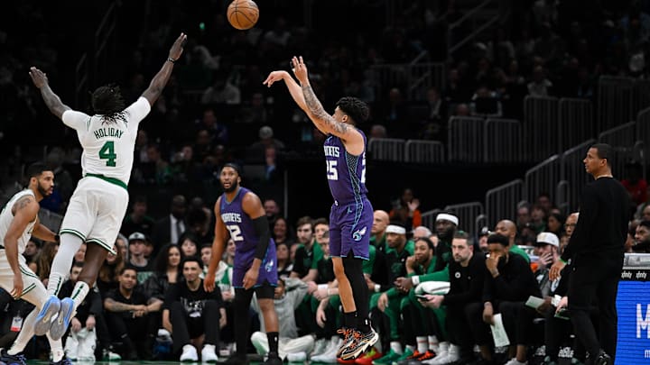 Apr 11, 2025; Boston, Massachusetts, USA; Charlotte Hornets guard KJ Simpson (25) shoots the ball against Boston Celtics guard Jrue Holiday (4) in the first half at TD Garden. Mandatory Credit: Eric Canha-Imagn Images