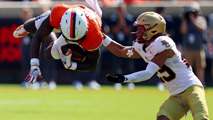 Oct 5, 2024; Charlottesville, Virginia, USA; Virginia Cavaliers running back Kobe Pace (5) dives into Boston College Eagles defensive back Cameron Martinez (29) during the third quarter at Scott Stadium. Mandatory Credit: Peter Casey-Imagn Images Oct 5, 2024; Charlottesville, Virginia, USA; Virginia Cavaliers running back Kobe Pace (5) dives into Boston College Eagles defensive back Cameron Martinez (29) during the third quarter at Scott Stadium. Mandatory Credit: Peter Casey-Imagn Images