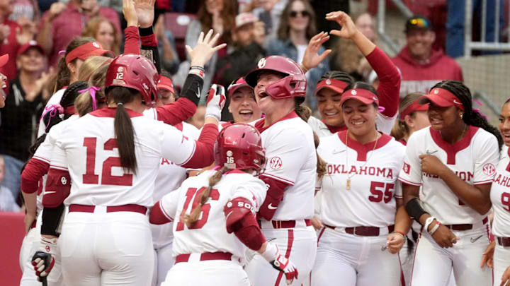 Oklahoma celebrates at home plate at Love's Field after freshman catcher Kendall Wells hit a home run.