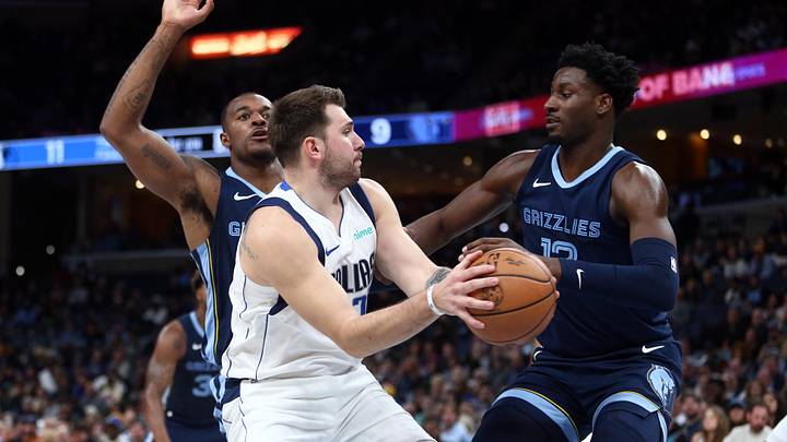 Oct 30, 2023; Memphis, Tennessee, USA; Dallas Mavericks guard Luka Doncic (77) spins toward the basket as Memphis Grizzlies forward Xavier Tillman (2) and forward-center Jaren Jackson Jr. (13) defend during the first half at FedExForum. Mandatory Credit: Petre Thomas-Imagn Images