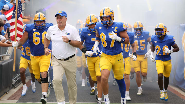 Sep 27, 2025; Pittsburgh, Pennsylvania, USA;  Pittsburgh Panthers head coach Pat Narduzzi (white) and tight end Jake Overman (87) lead the team onto the field to play the Louisville Cardinals at Acrisure Stadium. Mandatory Credit: Charles LeClaire-Imagn Images