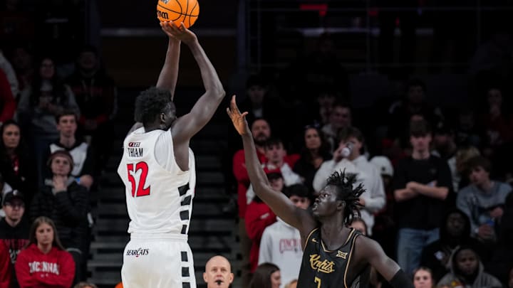 Feb 8, 2026; Cincinnati, Ohio, USA;  Cincinnati Bearcats center Moustapha Thiam (52) shoots against UCF Knights center John Bol (7) in the second half at Fifth Third Arena. Mandatory Credit: Aaron Doster-Imagn Images