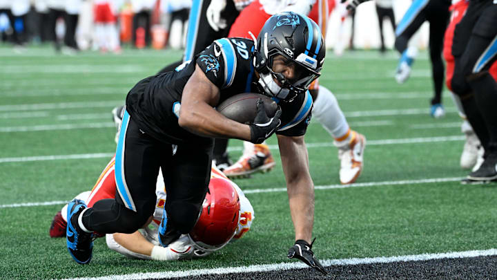 Nov 24, 2024; Charlotte, North Carolina, USA;  Carolina Panthers running back Chuba Hubbard (30) scores a touchdown as Kansas City Chiefs linebacker Leo Chenal (54) defends in the fourth quarter at Bank of America Stadium. Mandatory Credit: Bob Donnan-Imagn Images