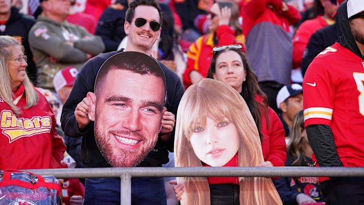 Kansas City Chiefs fans hold fathead signs of Travis Kelce and Taylor Swift during the game against the Denver Broncos.