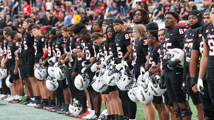 Nov 1, 2025; Houston, Texas, USA; Before the game the Houston Cougars stand for a moment of silence for Houston coach Kurt Hester at TDECU Stadium. Hester passed away on October 25, 2025, from stage IV melanoma after an eight-month battle with the disease. Mandatory Credit: Thomas Shea-Imagn Images