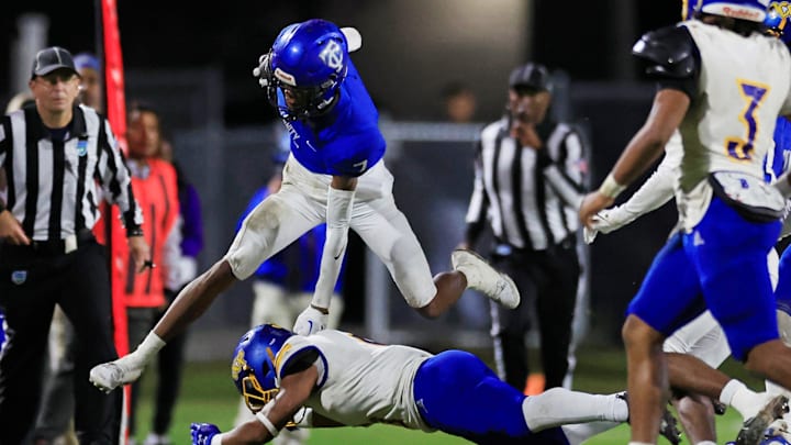Trinity Christian's Tre Stewart (7) hurdles Orlando Christian Prep's Adryan Marayne (6) during the second quarter of an FHSAA Region 1-1M high school football playoff matchup Friday, Nov. 24, 2023 at Trinity Christian Academy in Jacksonville, Fla. [Corey Perrine/Florida Times-Union]