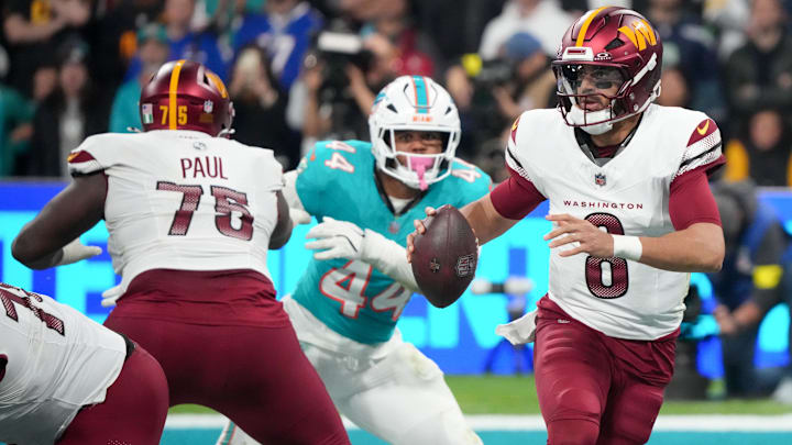 Washington Commanders quarterback Marcus Mariota (8) looks to pass the ball under pressure from Miami Dolphins linebacker Chop Robinson (44) in the third quarter during the 2025 NFL Madrid Game at Santiago Bernabeu Stadium.