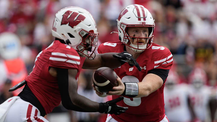 Sep 20, 2025; Madison, Wisconsin, USA;  Wisconsin Badgers quarterback Billy Edwards Jr. (9) hands the football off to running back Dilin Jones (7) during the first quarter against the Maryland Terrapins at Camp Randall Stadium. Mandatory Credit: Jeff Hanisch-Imagn Images