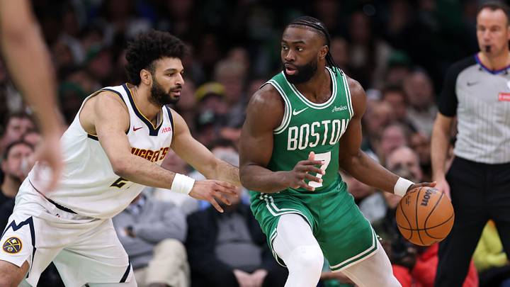 Mar 2, 2025; Boston, Massachusetts, USA; Boston Celtics forward Jaylen Brown (7) dribbles down the court defended by Denver Nuggets guard Jamal Murray (27) during the first half at TD Garden.