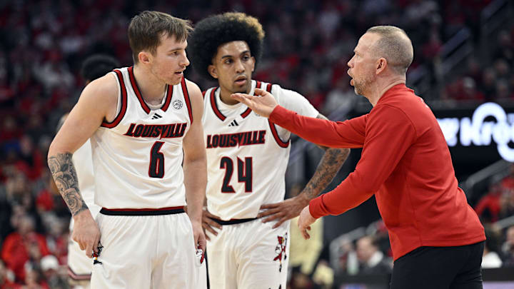 Feb 22, 2025; Louisville, Kentucky, USA;  Louisville Cardinals head coach Pat Kelsey talks with guard Reyne Smith (6) and guard Chucky Hepburn (24) during the first half against the Florida State Seminoles at KFC Yum! Center. Mandatory Credit: Jamie Rhodes-Imagn Images