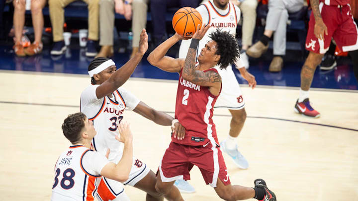 Alabama Crimson Tide guard Aden Holloway (2) goes up for a layup over Auburn Tigers forward Sebastian Williams-Adams (33) as Auburn Tigers take on Alabama Crimson Tide at Neville Arena in Auburn, Ala. on Saturday, Feb. 7, 2026. Auburn Tigers lead Alabama Crimson Tide 41-37 at halftime.