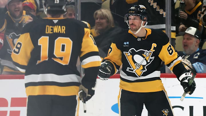 Apr 17, 2025; Pittsburgh, Pennsylvania, USA;  Pittsburgh Penguins center Sidney Crosby (87) reacts with center Connor Dewar (19) after Crosby scored a goal against the Washington Capitals during the second period at PPG Paints Arena. Mandatory Credit: Charles LeClaire-Imagn Images