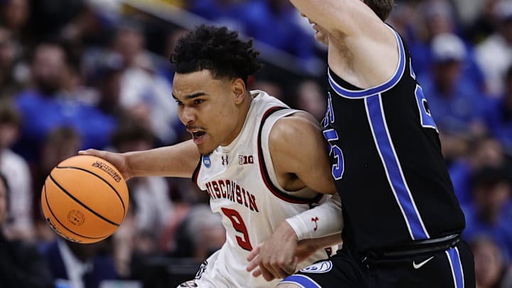 Mar 22, 2025; Denver, CO, USA; Wisconsin Badgers guard John Tonje (9) dribbles the ball past Brigham Young Cougars guard Dawson Baker (25) during the first half in the second round of the NCAA Tournament  at Ball Arena.