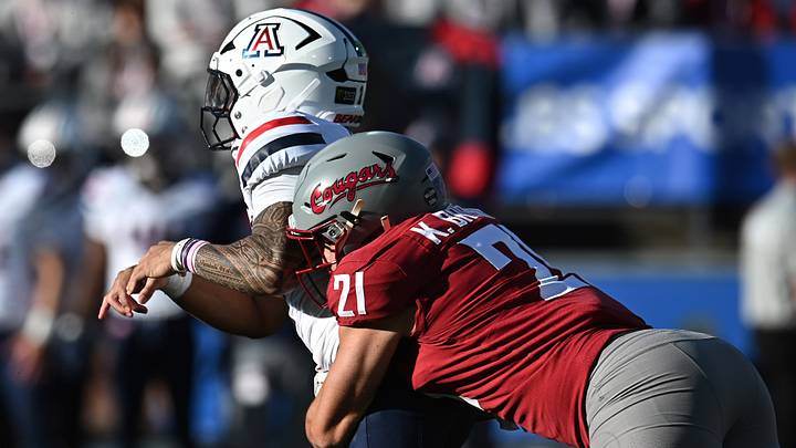 Arizona Wildcats quarterback Noah Fifita (1) is hit after the throw by Washington State Cougars linebacker Keith Brown (21) during the first half at Gesa Field at Martin Stadium. 
