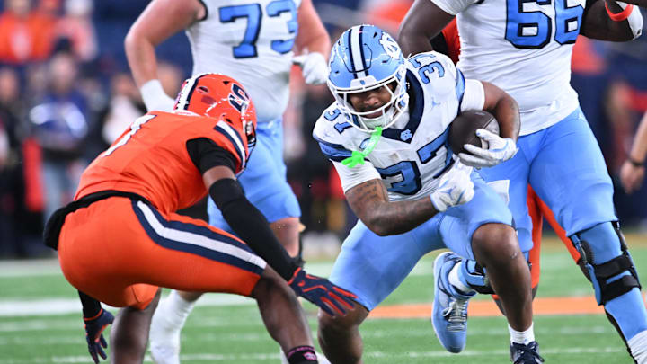 Oct 31, 2025; Syracuse, New York, USA; North Carolina Tar Heels running back Davion Gause (37) faces Syracuse Orange defensive back Demetres Samuel Jr. (1) on a run in the fourth quarter at the JMA Wireless Dome. Mandatory Credit: Mark Konezny-Imagn Images