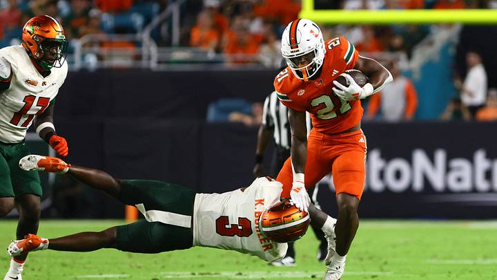 Sep 7, 2024; Miami Gardens, Florida, USA; Miami Hurricanes running back Jordan Lyle (21) breaks a tackle against Florida A&M Rattlers defensive back Kendall Bohler (3) during the third quarter at Hard Rock Stadium. Mandatory Credit: Sam Navarro-Imagn Images