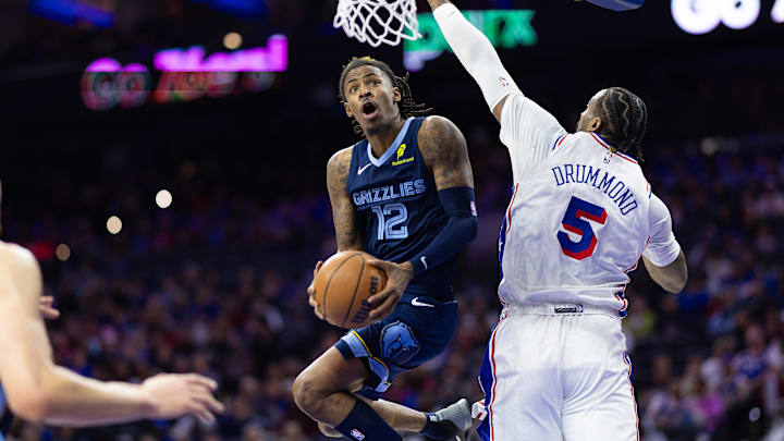 Nov 2, 2024; Philadelphia, Pennsylvania, USA; Memphis Grizzlies guard Ja Morant (12) drives for a score past Philadelphia 76ers center Andre Drummond (5) during the third quarter at Wells Fargo Center. Mandatory Credit: Bill Streicher-Imagn Images