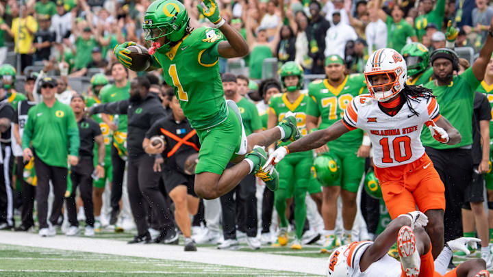 Oregon wide receiver Dakorien Moore hurdles Oklahoma State safety David Kabongo en route to a touchdown as the Oregon Ducks host the Oklahoma State Cowboys on Sept. 6, 2025, at Autzen Stadium in Eugene, Oregon.