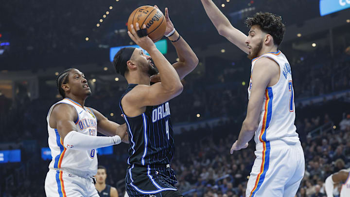 Jan 13, 2024; Oklahoma City, Oklahoma, USA; Orlando Magic guard Jalen Suggs (4) shoots between Oklahoma City Thunder forward Jalen Williams (8) and forward Chet Holmgren (7) during the first quarter at Paycom Center. Mandatory Credit: Alonzo Adams-Imagn Images Jan 13, 2024; Oklahoma City, Oklahoma, USA; Orlando Magic guard Jalen Suggs (4) shoots between Oklahoma City Thunder forward Jalen Williams (8) and forward Chet Holmgren (7) during the first quarter at Paycom Center. Mandatory Credit: Alonzo Adams-Imagn Images