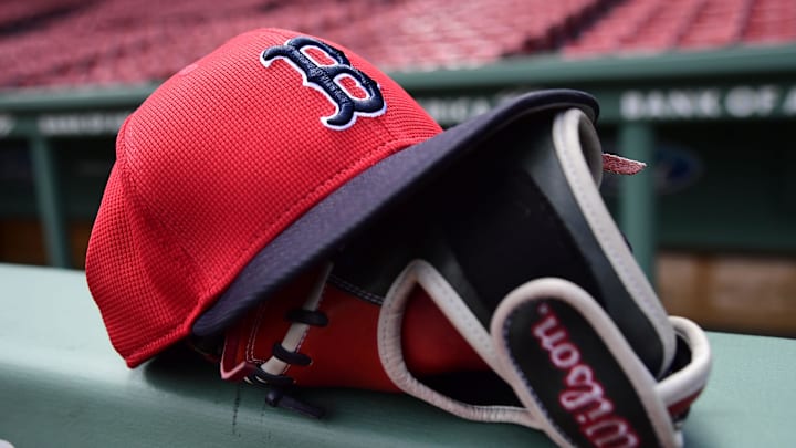 May 18, 2025; Boston, Massachusetts, USA;  A Boston Red Sox hat and glove rests on the railing by the dugout prior to a game against the Atlanta Braves at Fenway Park. Mandatory Credit: Bob DeChiara-Imagn Images