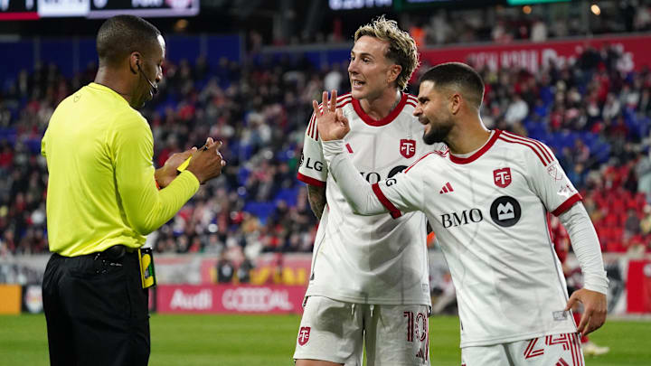 Toronto FC forward Federico Bernardeschi, middle, reacts to receiving a yellow card as Toronto FC forward Lorenzo Insigne argues alongsides him during the first half against the New York Red Bulls at Sports Illustrated Stadium. Mandatory Credit: Lucas Boland-Imagn Images