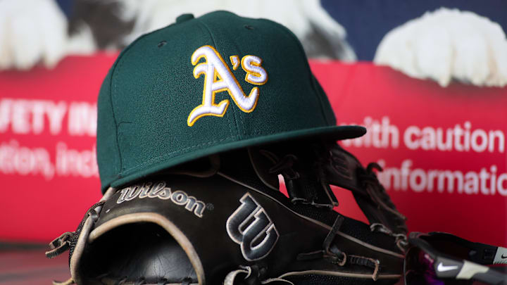 Jun 1, 2024; Atlanta, Georgia, USA; A detailed view of an Oakland Athletics hat and glove on the field against the Atlanta Braves in the sixth inning at Truist Park. Mandatory Credit: Brett Davis-Imagn Images