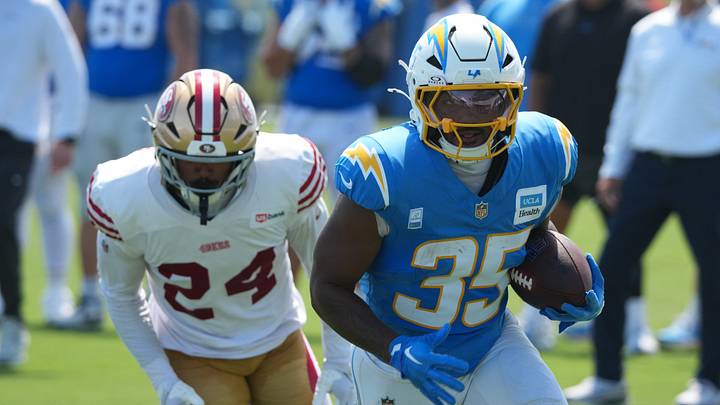Aug 18, 2026; El Segundo, CA, USA; Los Angeles Chargers linebacker Junior Colson (25) carries the ball against San Francisco 49ers safety Patrick McMorris (24) during joint practice at The Bolt. Mandatory Credit: Kirby Lee-Imagn Images