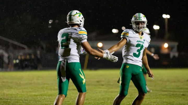 Jupiter's Luke Douglas (3) celebrates with Preston Douglas (2) during the Warriors' road rout of Royal Palm Beach on Friday, Sept. 29, 2023.