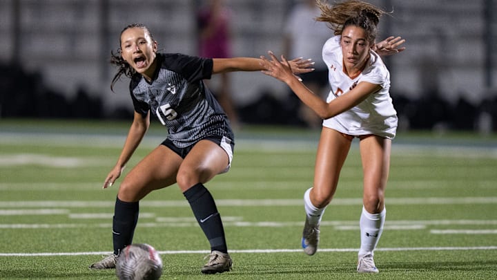 Vandegrift defender Sophie Minderhout (15) and Round Rock Westwood Kaleia Coughlin (5) fight for the ball as Westwood and Vandegrift girls face off in the UIL Regional soccer finals at The Pfield in Pflugerville Tuesday, April 1, 2025.