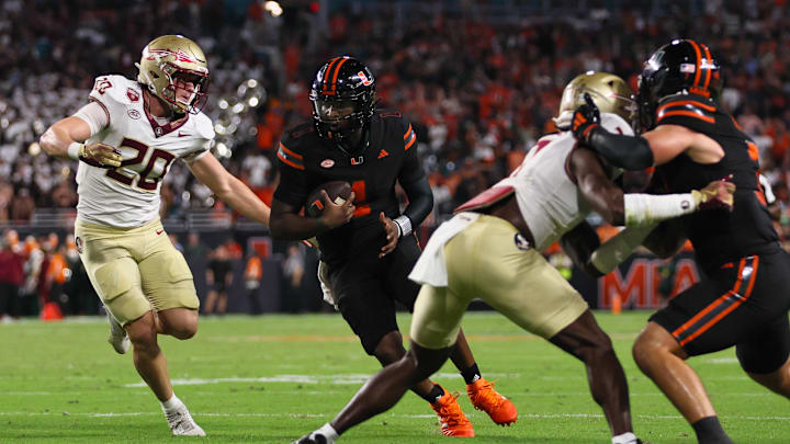 Oct 26, 2024; Miami Gardens, Florida, USA; Miami Hurricanes quarterback Cam Ward (1) runs with the football past Florida State Seminoles linebacker Blake Nichelson (20) during the second quarter at Hard Rock Stadium. Mandatory Credit: Sam Navarro-Imagn Images Oct 26, 2024; Miami Gardens, Florida, USA; Miami Hurricanes quarterback Cam Ward (1) runs with the football past Florida State Seminoles linebacker Blake Nichelson (20) during the second quarter at Hard Rock Stadium. Mandatory Credit: Sam Navarro-Imagn Images