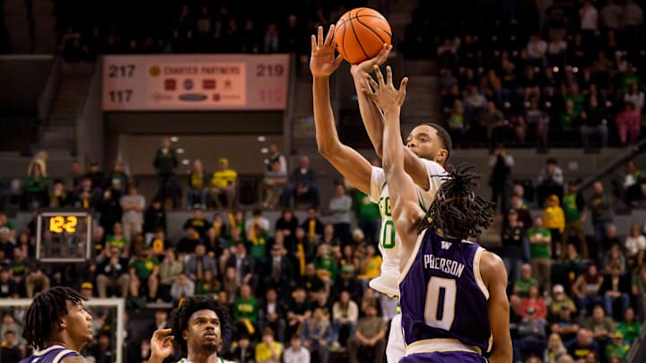 Oregon forward Kwame Evans Jr., right, is fouled by Washington's Quimari Peterson for a four-point play. 