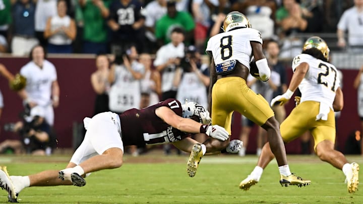 Aug 31, 2024; College Station, Texas, USA; Notre Dame Fighting Irish safety Adon Shuler (8) catches the ball for an interception as Texas A&M Aggies tight end Theo Melin Ohrstrom (17) lunges for the tackle during the second quarter at Kyle Field. Mandatory Credit: Maria Lysaker-Imagn Images