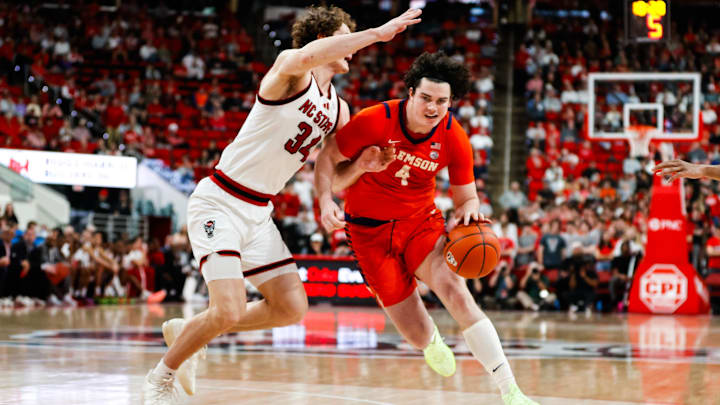 Feb 1, 2025; Raleigh, North Carolina, USA; Clemson Tigers forward Ian Schieffelin (4) dribbles with the ball guarded by North Carolina State Wolfpack forward Ben Middlebrooks (34) during the second half of the game at Lenovo Center.