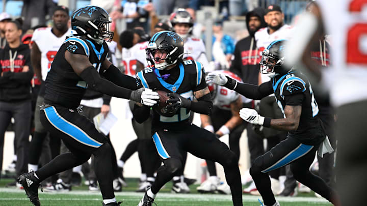 Dec 21, 2025; Charlotte, North Carolina, USA; Carolina Panthers safety Lathan Ransom (22) celebrates with linebacker Nic Scourton (11) and safety Nick Scott (21) after intercepting the ball to seal the victory in the fourth quarter at Bank of America Stadium. Mandatory Credit: Bob Donnan-Imagn Images