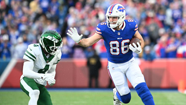 Buffalo Bills tight end Dalton Kincaid (86) tries to avoid a tackle by New York Jets cornerback D.J. Reed (4) after making a catch in the third quarter at Highmark Stadium. 