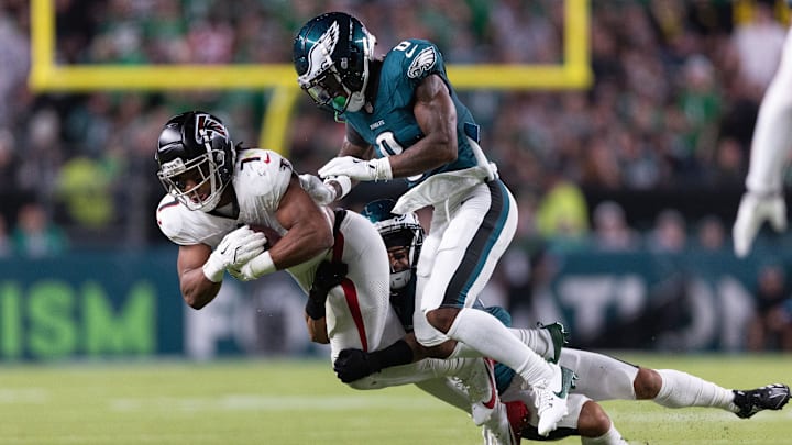 Sep 16, 2024; Philadelphia, Pennsylvania, USA; Philadelphia Eagles defensive end Bryce Huff (0) tackles Atlanta Falcons running back Bijan Robinson (7) after a catch during the second quarter at Lincoln Financial Field. Mandatory Credit: Bill Streicher-Imagn Images