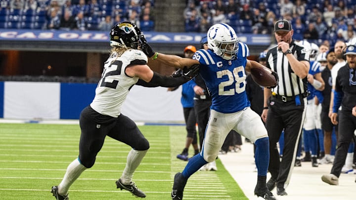 Jan 5, 2025; Indianapolis, Indiana, USA; Indianapolis Colts running back Jonathan Taylor (28) is pushed out of bounds by Jacksonville Jaguars safety Andrew Wingard (42) during overtime at Lucas Oil Stadium. Mandatory Credit: Marc Lebryk-Imagn Images