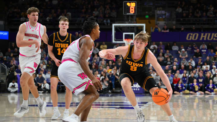 Feb 4, 2026; Seattle, Washington, USA; Iowa Hawkeyes forward Cooper Koch (8) dribbles the ball while guarded by Washington Huskies guard Quimari Peterson (0) during the second half at Alaska Airlines Arena at Hec Edmundson Pavilion. Mandatory Credit: Steven Bisig-Imagn Images