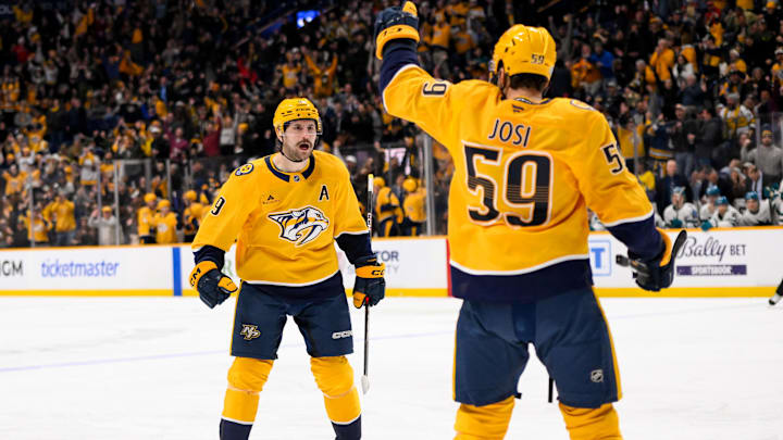 Jan 21, 2025; Nashville, Tennessee, USA;  Nashville Predators left wing Filip Forsberg (9) cebrates the goal of defenseman Roman Josi (59) against the San Jose Sharks during the third period at Bridgestone Arena. Mandatory Credit: Steve Roberts-Imagn Images