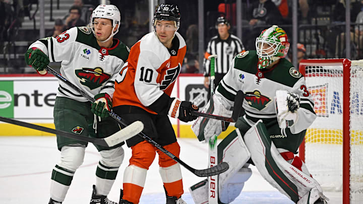 Oct 18, 2025; Philadelphia, Pennsylvania, USA; Philadelphia Flyers right wing Bobby Brink (10) battles for position against Minnesota Wild center Marco Rossi (23) and goaltender Jesper Wallstedt (30) during the first period at Wells Fargo Center.