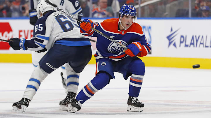 Sep 22, 2024; Edmonton, Alberta, CAN; Edmonton Oilers Forward Matt Savoie (22) battles with Winnipeg Jets forward Markus Loponen (65) while keeping an eye on a loose puck at Rogers Place. Mandatory Credit: Perry Nelson-Imagn Images
