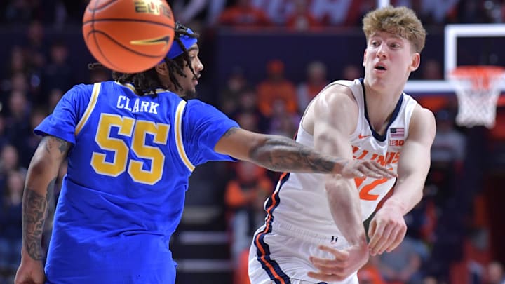 Feb 11, 2025; Champaign, Illinois, USA;  Illinois Fighting Illini guard Kasparas Jakucionis (32) passes the ball by UCLA Bruins guard Skyy Clark (55)  during the first half at State Farm Center. Mandatory Credit: Ron Johnson-Imagn Images