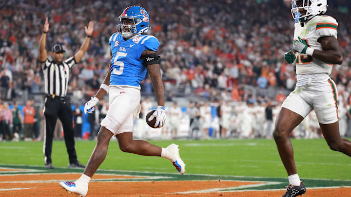 Jan 8, 2026; Glendale, AZ, USA; Mississippi Rebels running back Kewan Lacy (5) rushes the ball for a touchdown against Miami Hurricanes defensive back Jr. Romanas Frederique (29) in the first half during the 2026 Fiesta Bowl and semifinal game of the College Football Playoff at State Farm Stadium. Mandatory Credit: Mark J. Rebilas-Imagn Images