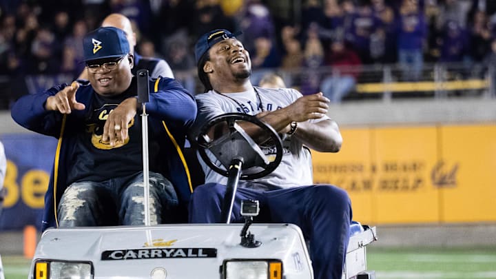 Marshawn Lynch (R) drives the injury cart with rapper E-40 on the 10-year anniversary of driving the cart after a Cal win over Washington